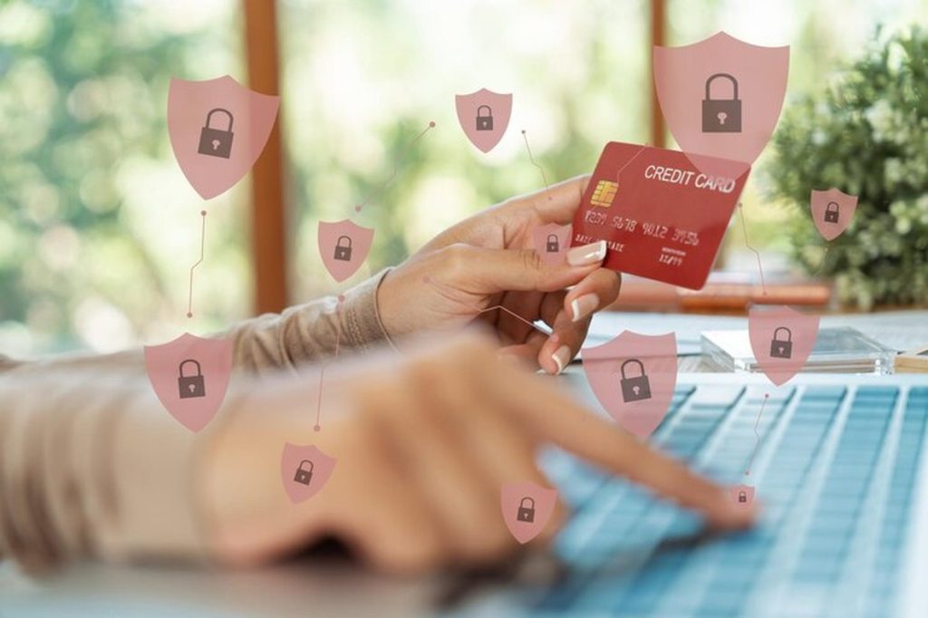 Close-up of a person holding a credit card while shopping online, with digital security icons floating around — visually emphasizing how certain cards offer purchase protection during online transactions.