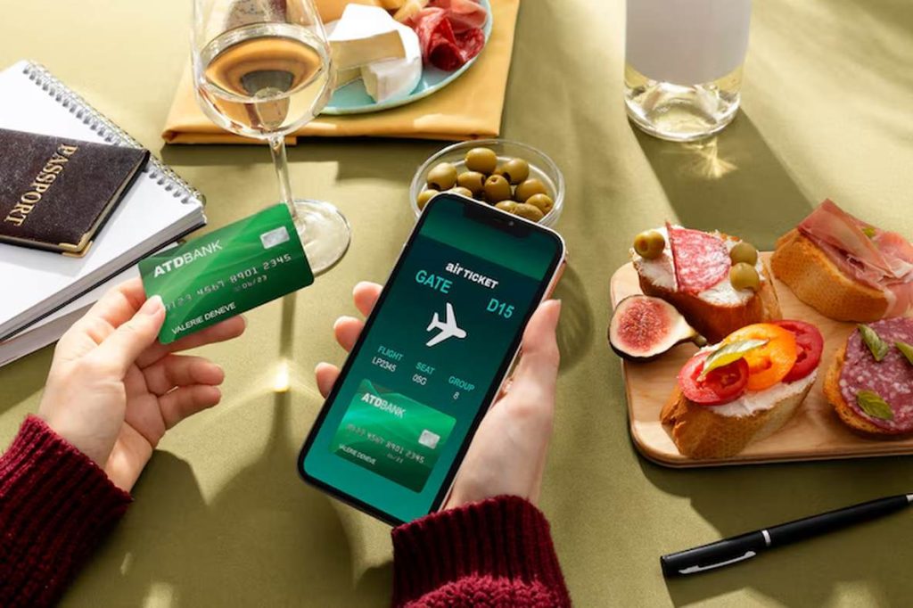Traveler holding a green credit card and a smartphone displaying a digital boarding pass, surrounded by travel documents and gourmet snacks — representing the smart use of credit cards to maximize airline miles.